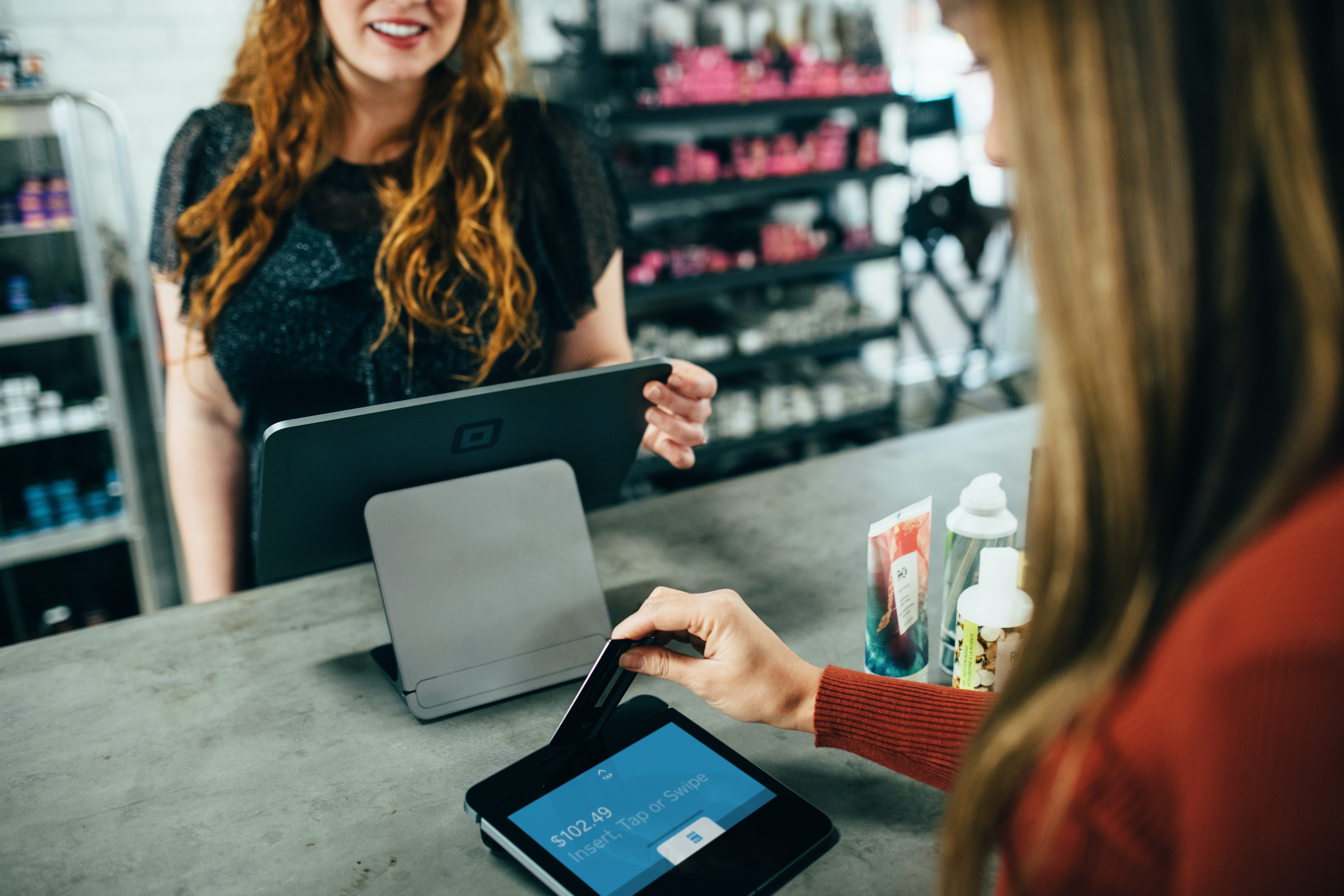 A red haired cashier registering a credit card payment